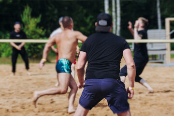 Beach volleyball game, team of adult friends athletes play volleyball by the sea, players on the...