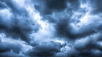 Obraz premium Dramatic Dark Clouds Illuminated by Distant Light Creating a Moody Atmosphere in the Sky