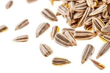 Striped sunflower seeds falling on white background, showing detail and texture.
