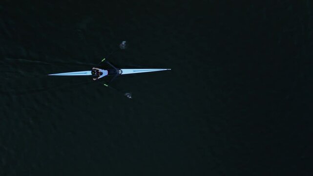Rowing on calm waters at dawn with a single sculler in a competitive setting