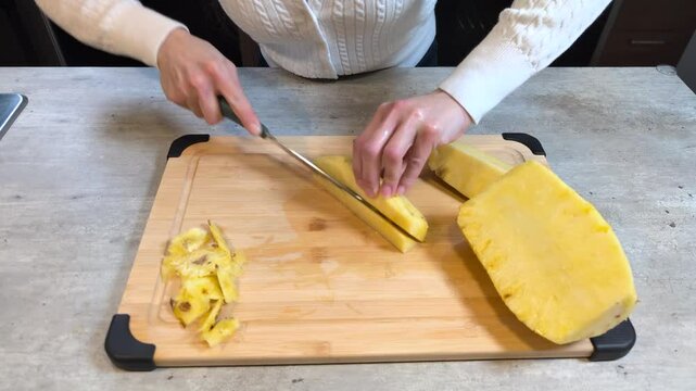 Cutting pineapple chunks large knife countertop food preparation tropical fruit