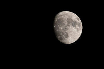 Sharp photograph of a waxing gibbous moon against a black sky, revealing detailed craters and surface textures. Perfect for astronomy and space-related projects.
