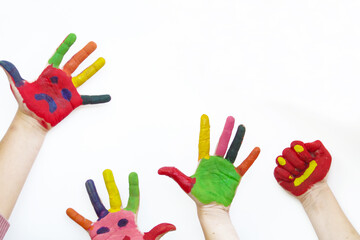 children with hands painted with multicolored paint on a white background. multi-colored paint on the hands