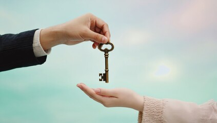 Young man hands house keys to girlfriend on isolated turquoise background.