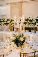 Elegant wedding reception table arrangement with floral decorations and candle centerpieces in a luxurious venue