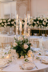 Elegant floral table centerpieces enhance a luxurious event setting with candles and fine dining elements at dusk