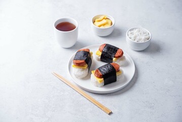 Sausage omelette sushi Musubi in a plate on a white background