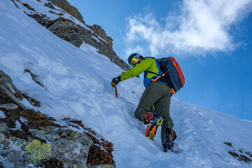 Alpinista affronta la cima Ovest del Pizzo Grandinagia in inverno, Alpi Svizzere