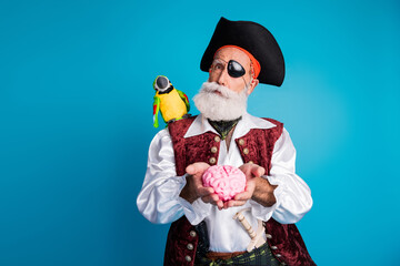 Photo portrait of senior funny pirate grandpa hold brain wear masquerade party costume isolated...