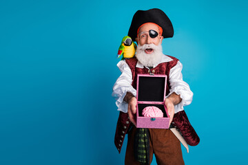 Photo portrait of senior funny pirate grandpa hold brain box wear masquerade party costume isolated blue color background