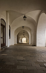 Obraz premium Beautiful Gothic arcade in the historic city. Old architectural style. Arcade with Gothic ceiling. Beautiful architectural background. Gothic, style, composition, view.