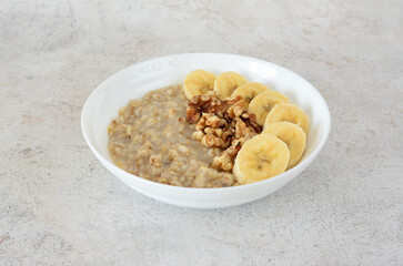 A delicious bowl of oatmeal with banana slices and walnuts