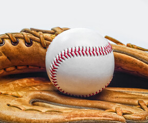 Classic baseball glove holding a ball with red stitches closeup