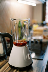 Blender whips up a red drink on a table in the kitchen