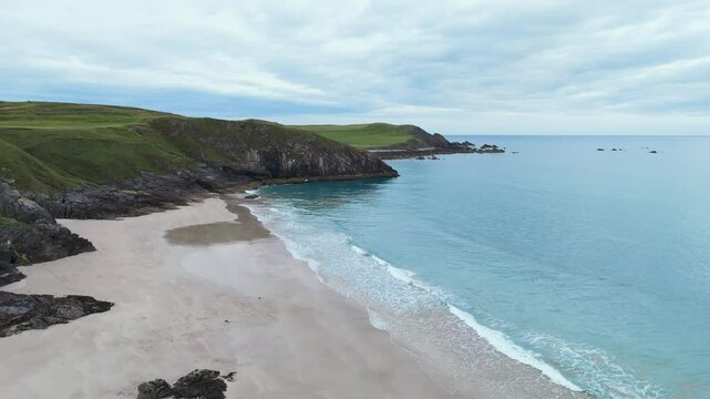 Aerial drone views Durness Beach reveal golden sands, turquoise waters and cliffs. A breathtaking panoramic viewpoint where Scotland&rsquo;s wild beauty meets the untamed power of the North Atlantic Ocean.
