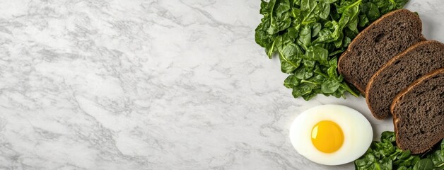Healthy breakfast spread featuring spinach, whole grain bread, and a sunny side up egg on a marble surface
