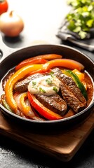 Sizzling beef steak fajitas, a delicious home-cooked meal featu tender strips of marinated steak and colorful bell peppers in a cast iron skillet served with a creamy sauce.