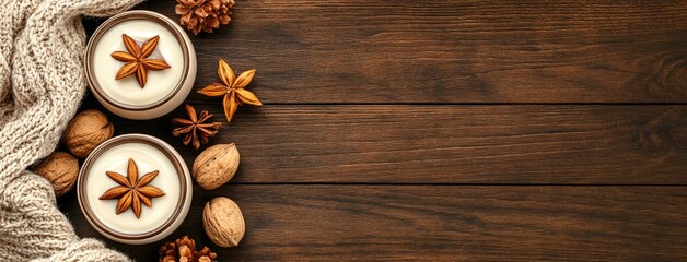 Cozy arrangement of scented candles with star anise and walnuts on wooden surface during autumn season
