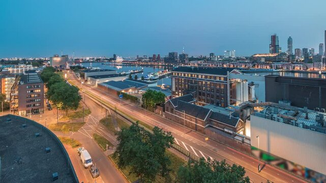 Aerial panoramic view over towers in Maashaven night to day transition timelapse with moored ships, Katendrecht and Maas River, Rotterdam. Traffic near factory converted into office and event space