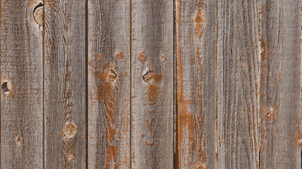 Close-up color photo of a rustic rough wooden fence showing textured wood grain with copy space