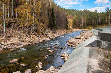 Southern Urals, a rapids on the mountain river Aigir. The reinforced river shore at the railway station.