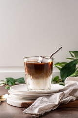  iced latte in a clear glass, showing distinct layers of milk and coffee. 