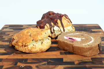Three Delicious Desserts On A Cutting Board Before A White Background
