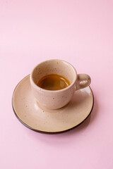 espresso coffee in a beige cup isolated on the pink background