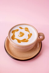 Flat White (latte) coffee in a beige cup isolated on the pink background. Latte art