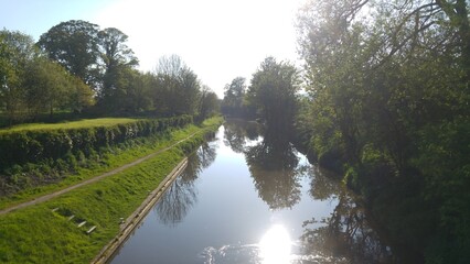 Tranquil Canal with Reflections of Trees on a Sunny Day.  A peaceful canal scene with still waters...