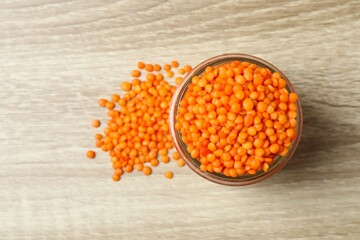 Red lentils in a jar on a wooden background