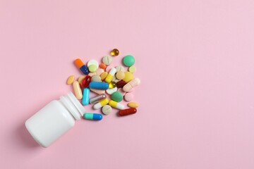 Various pills with white bottle on color background, top view