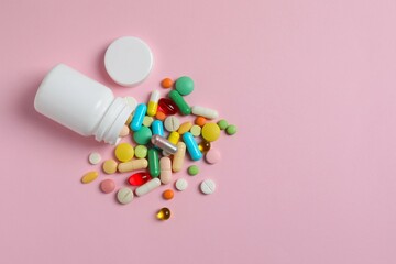Various pills with white bottle on color background, top view