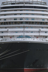 Naklejka premium Brand new ocean liner cruiseship cruise ship Queen Anne in port of Rotterdam, Holland with skyscraper downtown city skyline