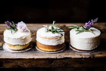 Rustic floral-topped cakes with creamy frosting on wooden table