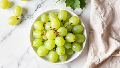 Fresh green grapes in a bowl on a marble countertop