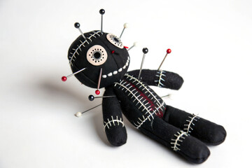 A stylized voodoo doll with black fabric, featuring white stitching and colorful pins embedded throughout its body.