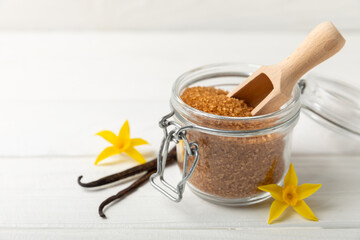 Aromatic vanilla sugar. Vanilla pods. Vanilla sticks, brown and white sugar in a bowl on a textured background. Vanilla flowers, spices and herbs for desserts and baking. Space for text. Copy space