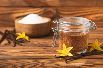 Aromatic vanilla sugar. Vanilla pods. Vanilla sticks, brown and white sugar in a bowl on a textured background. Vanilla flowers, spices and herbs for desserts and baking. Space for text. Copy space