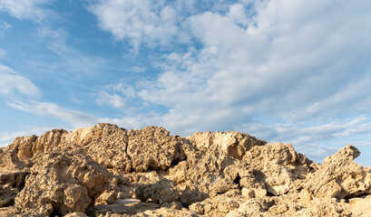 Eroded rocky coastline meeting a cloudy blue sky