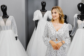 The bride-to-be came to a wedding dress salon to buy a dress. A beautiful woman chooses a wedding...