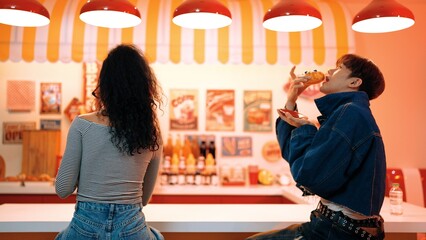 Happy diverse customer sitting and waiting for waiter serving food. Multicultural people waiting and eating fast food and talking with his colleague while wearing casual shirt. Happy meal. Regalement.
