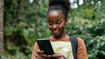 African woman uses smartphone to navigate outdoors in lush green area during daytime, African woman looking at the map on the phone outdoors