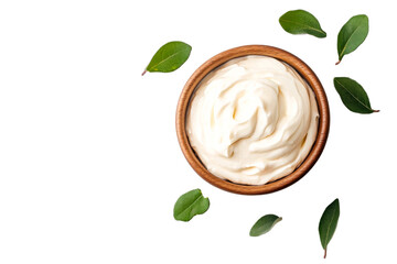Creamy mayonnaise in wooden bowl with green leaves on black, cut out transparent