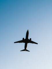 Passenger Jet plane soaring high in clear blue sky, climbing after takeoff from airport runway, embodying spirit of travel, excitement of business trips. symbolizing freedom and professional ambition