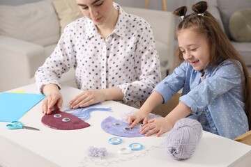 Woman and little girl making paper jellyfish at home. Child handmade craft © New Africa