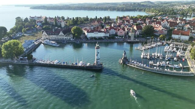 Orbit flight around lighthouse and Harbour entrance panorama with Bavarian Lion sculpture on island Lindau at Lake Constance (Bodensee) in Germany
