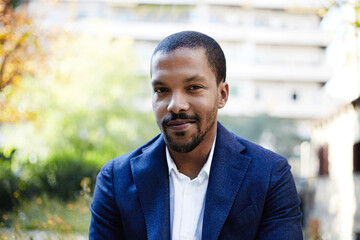 Naklejka premium African American young man wearing blue suit posing outdoor and looking at the camera.