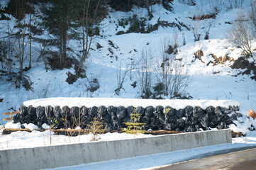 Winter landscape depicting a line of covered materials resting beneath a thick blanket of snow,...