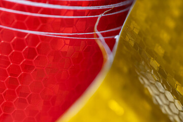 Close-up of red and yellow reflective safety tape  
A macro close-up of red and yellow reflective...